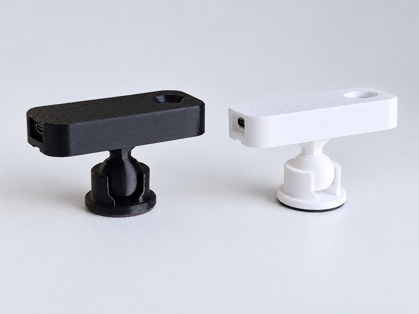 Black and white StoveDetector units on matching adjustable ball-joint mounts, viewed from the side.